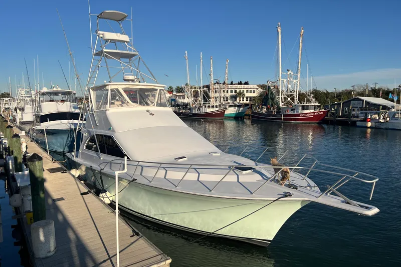 Slide: The Image of 1996 Ocean Yachts 48 Super Sport docked at marina under clear blue sky. - 61