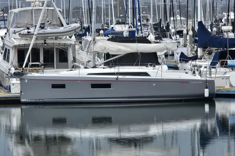 The Image of 2023 Beneteau Oceanis 34.1 sailboat docked in a marina, surrounded by other boats. - 0