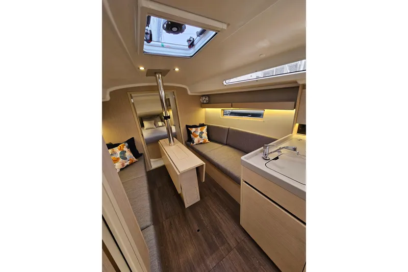 Slide: The Image of Interior of 2023 Beneteau Oceanis 34.1 yacht, featuring modern seating and compact kitchen. - 11