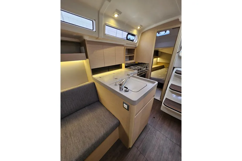 Slide: The Image of Interior of 2023 Beneteau Oceanis 34.1 yacht, featuring modern kitchen and cozy seating area. - 13