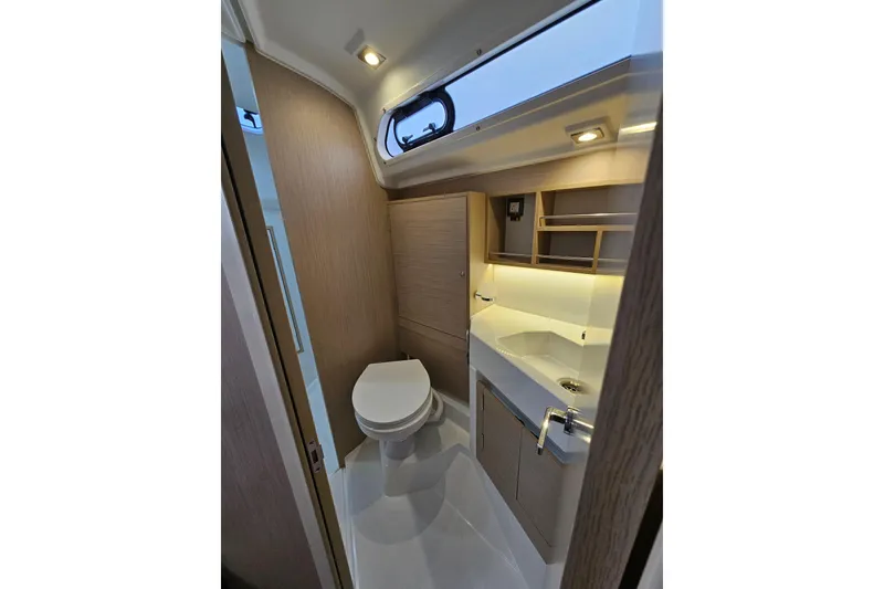 Slide: The Image of 2023 Beneteau Oceanis 34.1 yacht bathroom with modern fixtures and wood accents. - 17