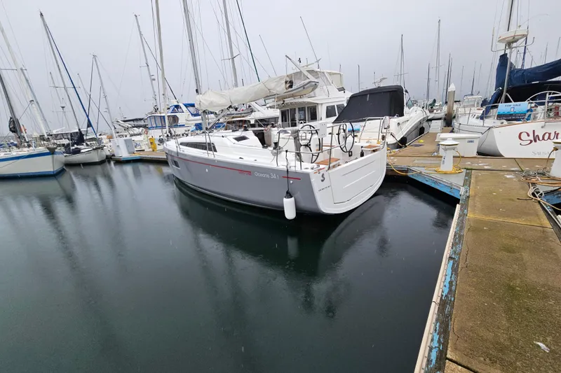 Slide: The Image of 2023 Beneteau Oceanis 34.1 sailboat docked in a marina, surrounded by other boats. - 4