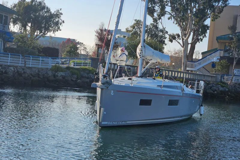 Slide: The Image of 2023 Beneteau Oceanis 34.1 sailboat docked near a scenic waterfront. - 5