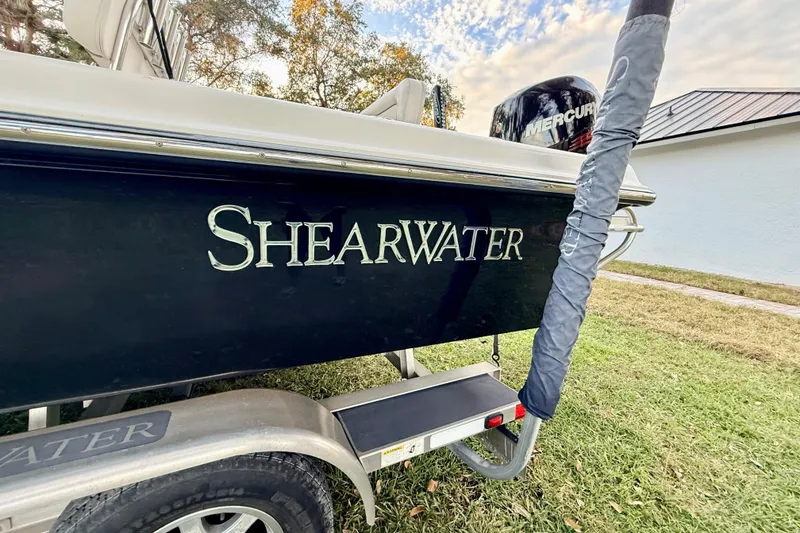 Slide: The Image of 2012 ShearWater 25LTZ boat on trailer, featuring sleek black hull design. - 12