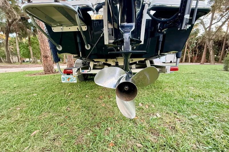 Slide: The Image of Rear view of a 2012 ShearWater 25LTZ boat on grass, showing the propeller. - 16