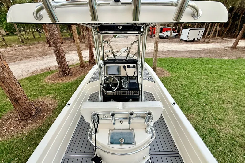 Slide: The Image of 2012 ShearWater 25LTZ boat interior with steering console, set in a wooded area. - 21
