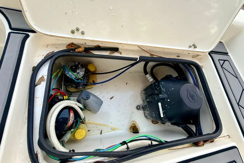 Slide: The Image of Open storage compartment in 2012 ShearWater 25LTZ boat, showing wiring and equipment. - 24