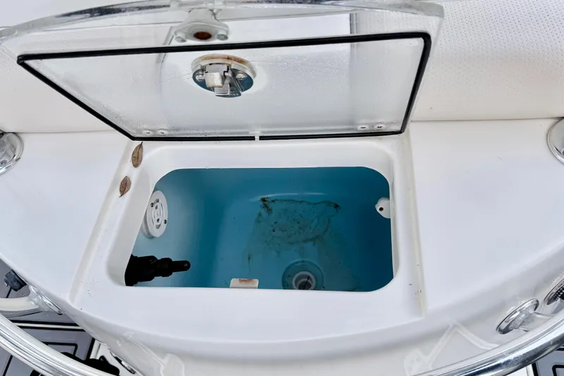 Slide: The Image of Open storage compartment on 2012 ShearWater 25LTZ boat, featuring a clear lid. - 26