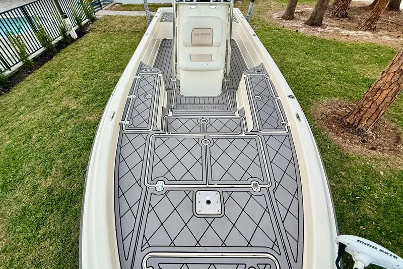 Slide: The Image of 2012 ShearWater 25LTZ boat with custom deck design, parked on grass. - 29