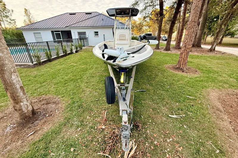 Slide: The Image of 2012 ShearWater 25LTZ boat on trailer, parked on grass near house and trees. - 5