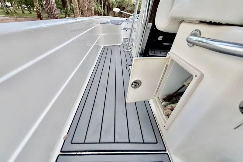 Slide: The Image of 2012 ShearWater 25LTZ boat interior with open storage compartment and sleek flooring. - 61