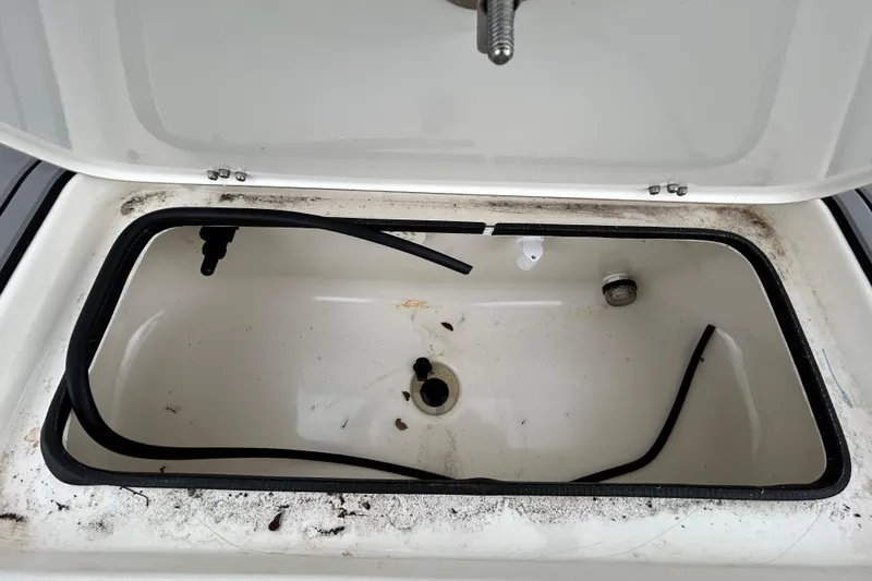 Slide: The Image of Open storage compartment on 2012 ShearWater 25 LTZ boat, showing interior details. - 64