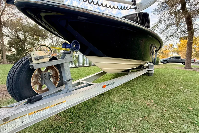 Slide: The Image of 2012 ShearWater 25LTZ boat on trailer, parked on grass, side view. - 7