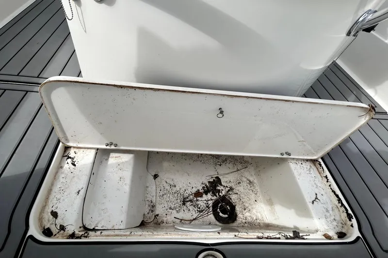 Slide: The Image of Open storage compartment on 2012 ShearWater 25 LTZ boat, showing interior condition. - 73