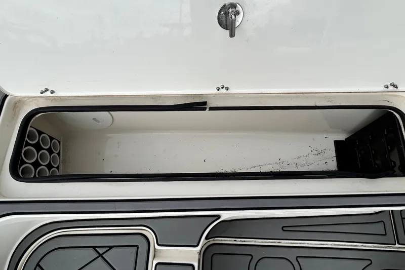 Slide: The Image of Storage compartment of a 2012 ShearWater 25 LTZ boat, featuring a secure latch. - 76