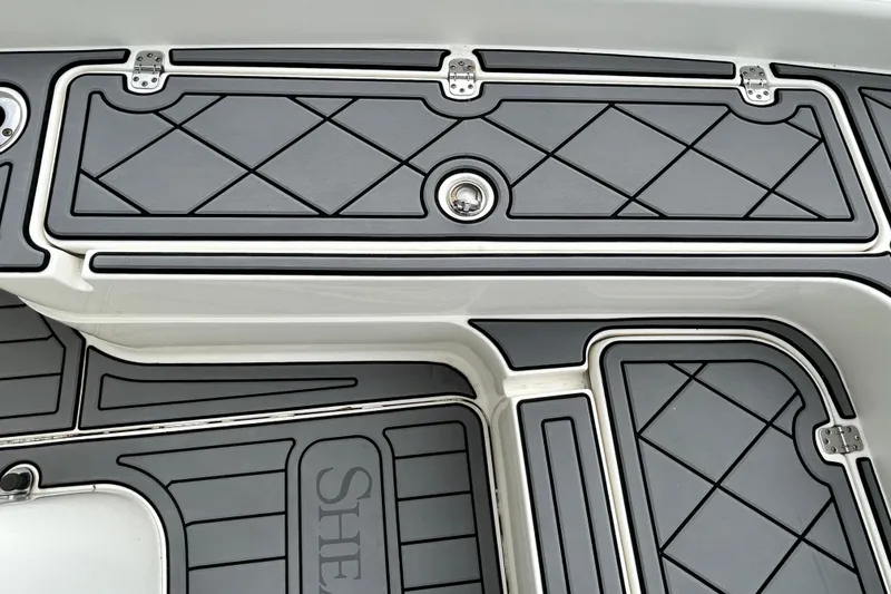 Slide: The Image of 2012 ShearWater 25 LTZ boat deck with sleek, diamond-patterned design and secure latches. - 80