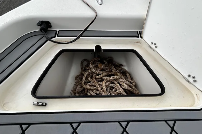 Slide: The Image of Open storage compartment with rope on a 2012 ShearWater 25 LTZ boat. - 85