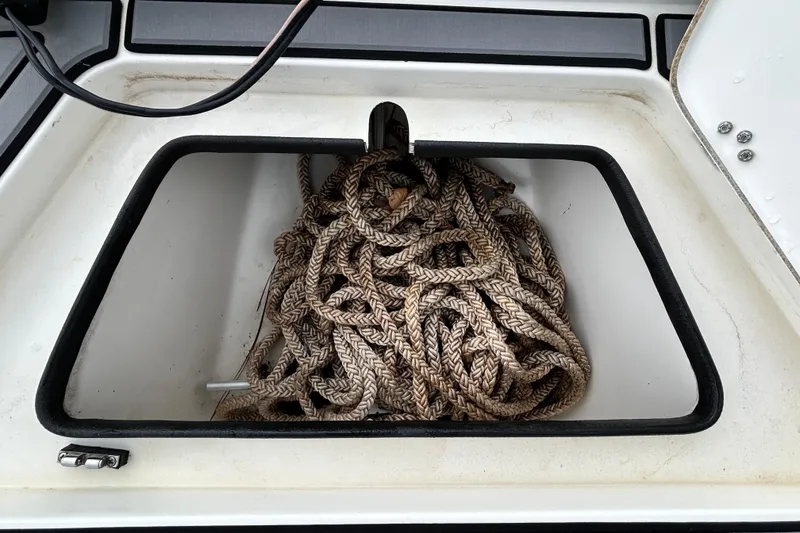 Slide: The Image of Storage compartment with coiled rope on a 2012 ShearWater 25 LTZ boat. - 86