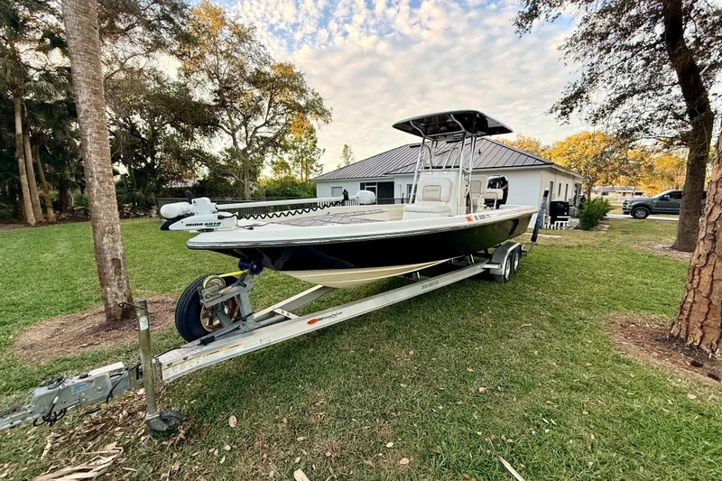 Slide: The Image of 2012 ShearWater 25LTZ boat on trailer, parked on grass near house and trees. - 9