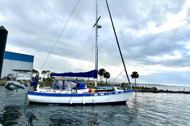 The Image of 1987 Morgan 41 Out Island Classic sailboat docked on a cloudy day. - 0
