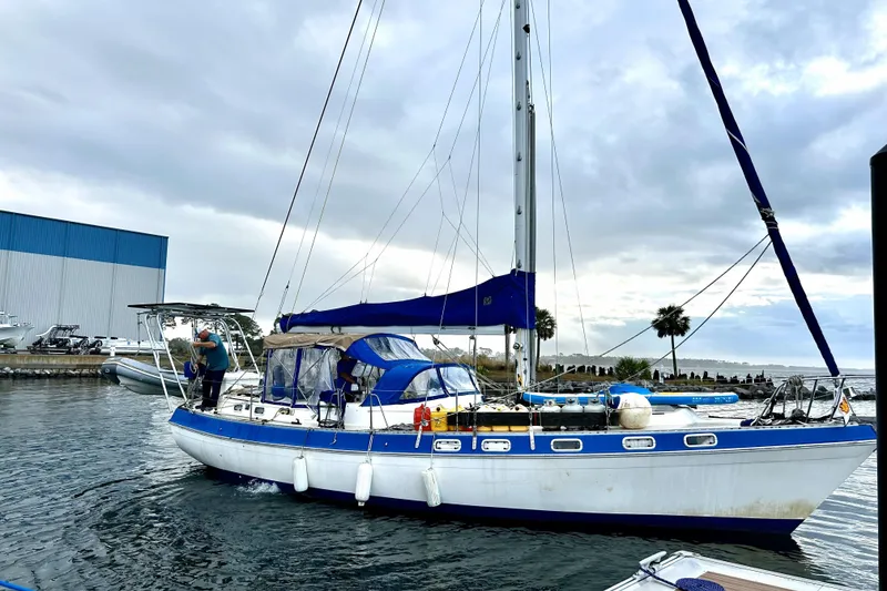 Slide: The Image of 1987 Morgan 41 Out Island Classic sailboat docked, featuring blue and white design. - 1