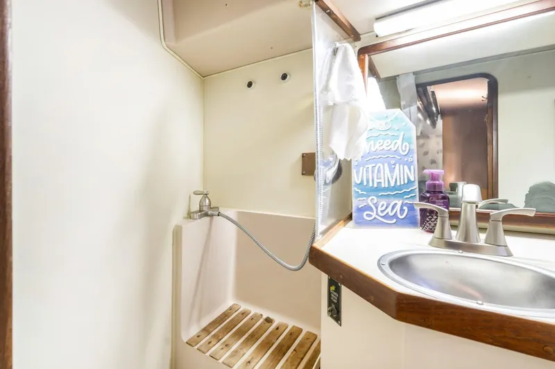 Slide: The Image of 1987 Morgan 41 Out Island Classic yacht bathroom with sink, shower, and nautical decor. - 14