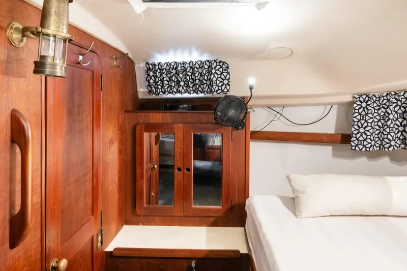 Slide: The Image of Interior of 1987 Morgan 41 Out Island Classic yacht with wood paneling and cozy bedding. - 16