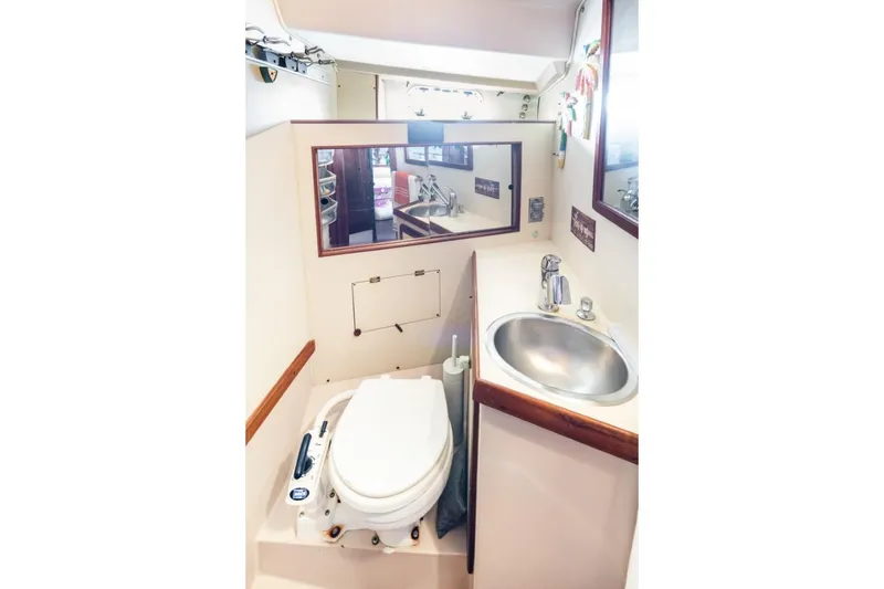 Slide: The Image of 1987 Morgan 41 Out Island Classic yacht bathroom with toilet, sink, and mirror. - 23