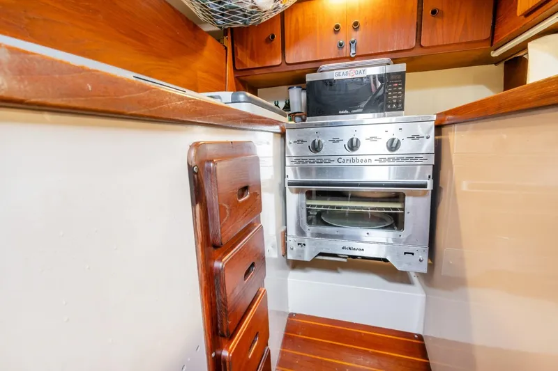 Slide: The Image of 1987 Morgan 41 Out Island Classic yacht kitchen with stove and wooden cabinetry. - 27