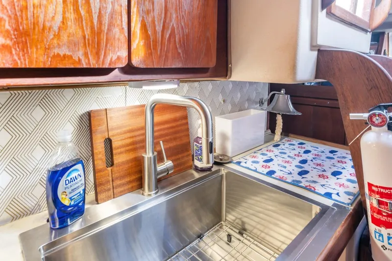 Slide: The Image of 1987 Morgan 41 Out Island Classic yacht kitchen with stainless steel sink and nautical decor. - 28