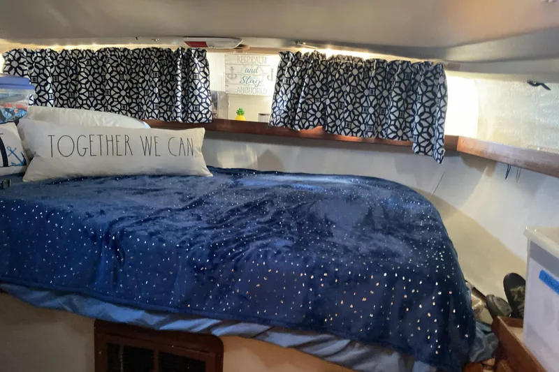 Slide: The Image of Cozy cabin interior of 1987 Morgan 41 Out Island Classic with blue bedding and patterned curtains. - 32