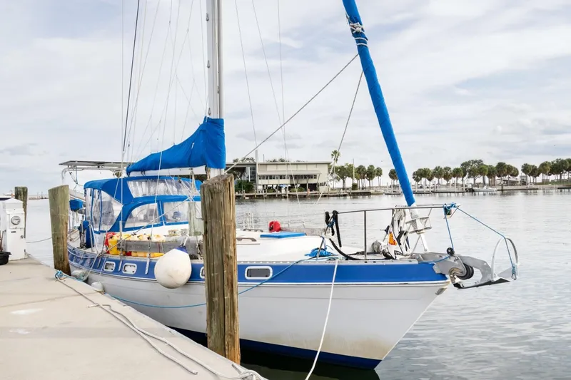 Slide: The Image of 1987 Morgan 41 Out Island Classic sailboat docked at marina with blue accents. - 4
