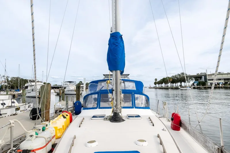 Slide: The Image of 1987 Morgan 41 Out Island Classic sailboat docked at a marina, featuring blue covers. - 6