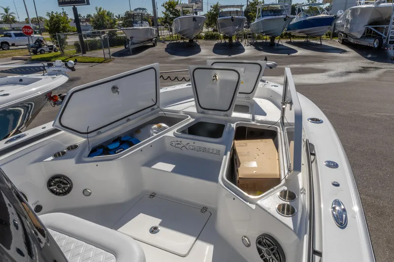 Slide: The Image of 2026 Crevalle 26 HCO boat with open storage compartments in a marina setting. - 18