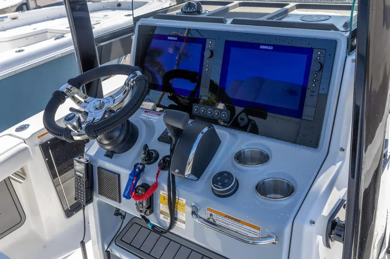 Slide: The Image of Helm of 2026 Crevalle 26 HCO boat with dual Simrad displays and steering wheel. - 3