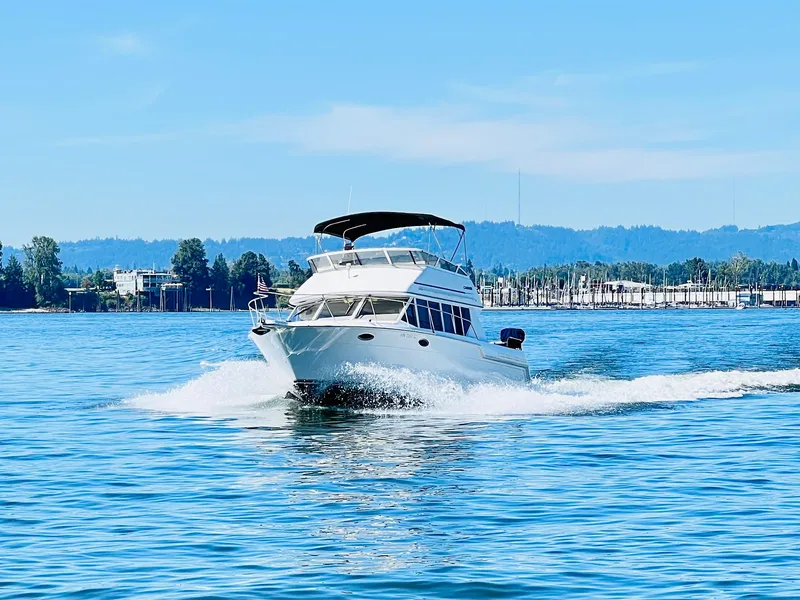 Slide: The Image of 1997 Carver 320 Voyager cruising on calm water under clear sky. - 12