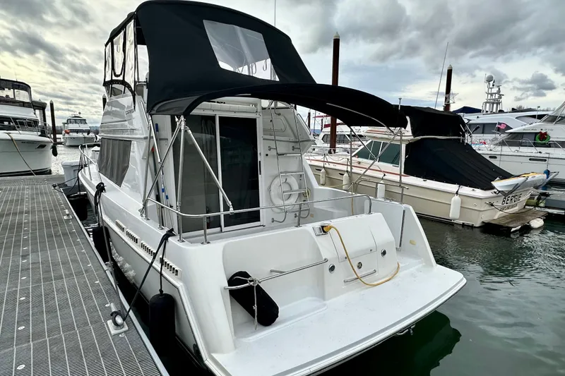 Slide: The Image of 1997 Carver 320 Voyager docked at marina under cloudy skies. - 15