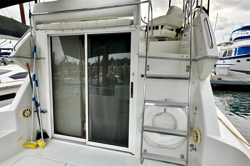 Slide: The Image of 1997 Carver 320 Voyager boat with ladder, sliding door, and docked at marina. - 18