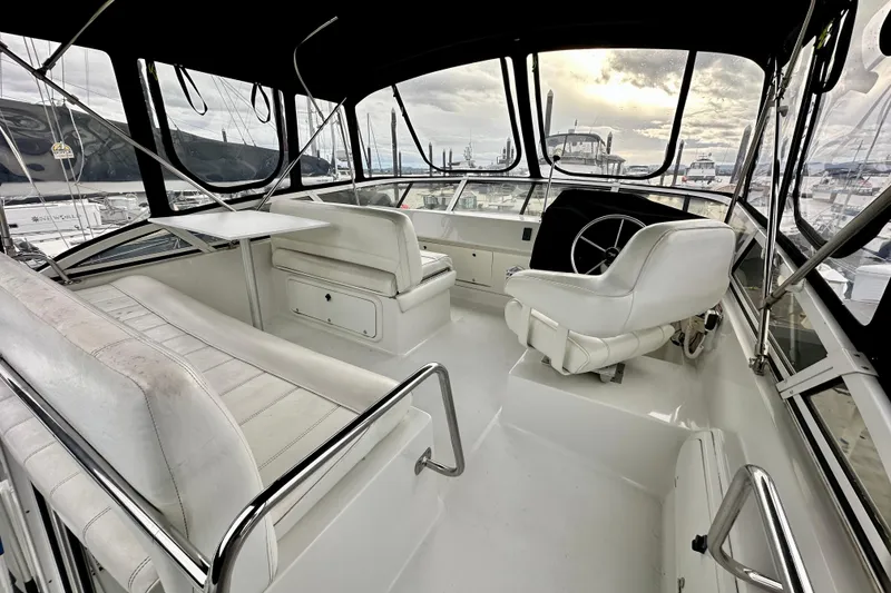Slide: The Image of Interior of 1997 Carver 320 Voyager boat with white seating and steering wheel. - 19