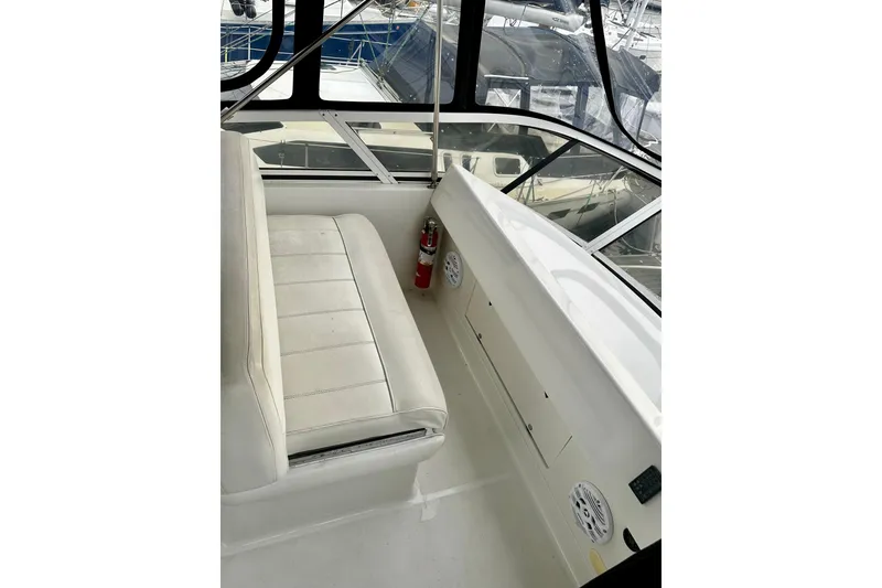 Slide: The Image of 1997 Carver 320 Voyager interior with white seating and windows, featuring a fire extinguisher. - 20