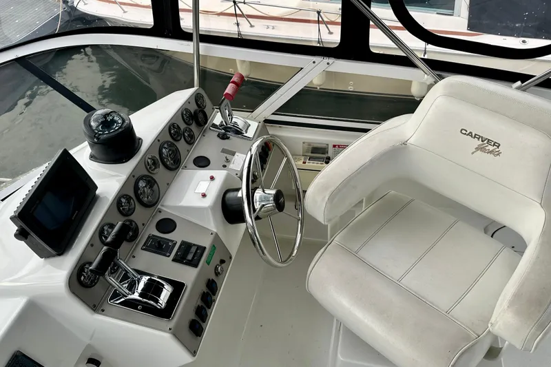 Slide: The Image of 1997 Carver 320 Voyager helm with steering wheel, gauges, and captain's chair. - 21