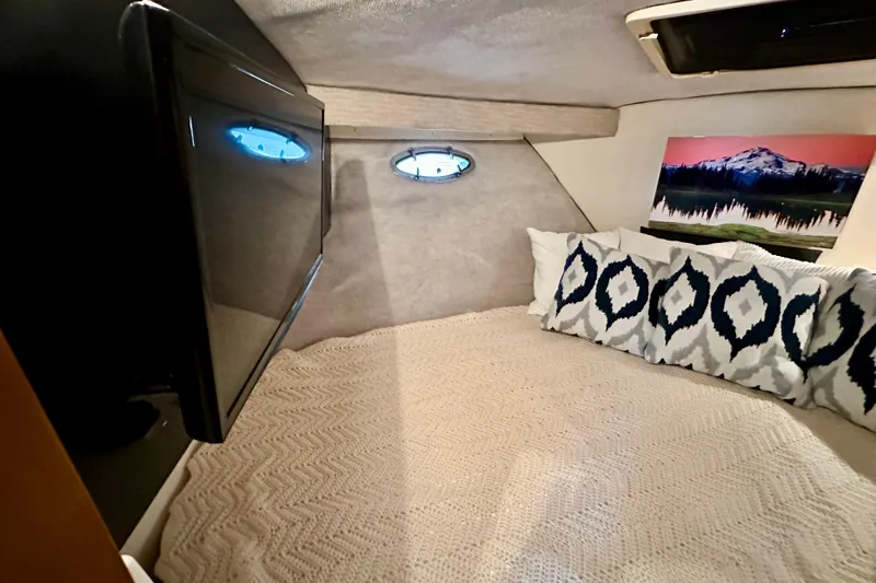 Slide: The Image of Cozy cabin interior of 1997 Carver 320 Voyager with bed, pillows, and wall art. - 25