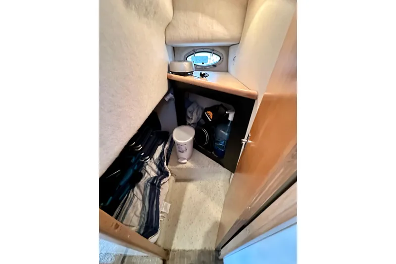 Slide: The Image of Interior storage area of 1997 Carver 320 Voyager boat with porthole and supplies. - 26