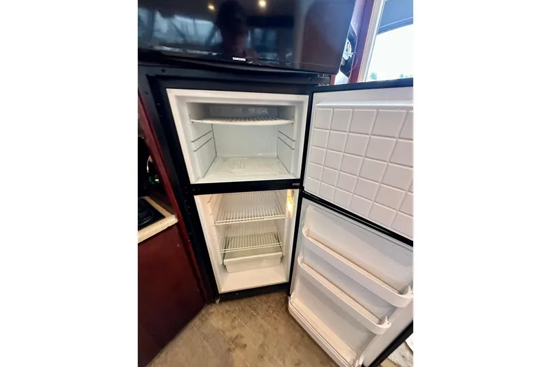 Slide: The Image of Refrigerator inside 1997 Carver 320 Voyager boat, open with empty shelves. - 27