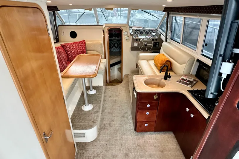 Slide: The Image of Interior of a 1997 Carver 320 Voyager yacht with seating, table, and kitchenette. - 3