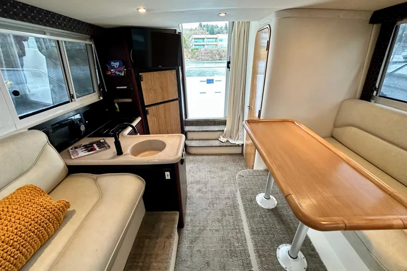 Slide: The Image of Interior of 1997 Carver 320 Voyager yacht with cozy seating and kitchenette. - 4