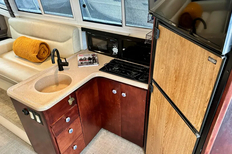 Slide: The Image of Interior of 1997 Carver 320 Voyager yacht kitchen with sink, stove, and fridge. - 6