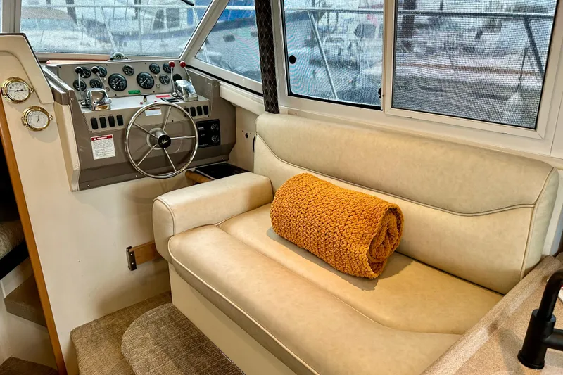 Slide: The Image of Interior of 1997 Carver 320 Voyager with helm and cozy seating area. - 7