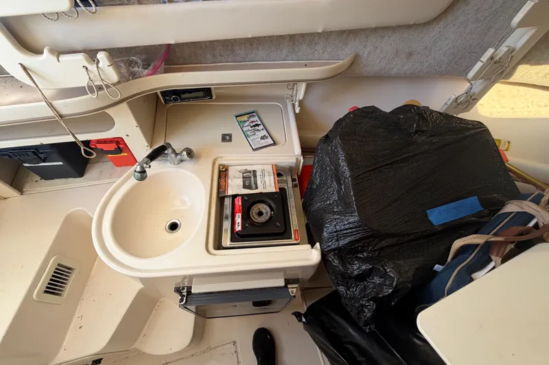 Slide: The Image of 2001 Grady-White Sailfish 282 boat interior with sink and stove setup. - 12