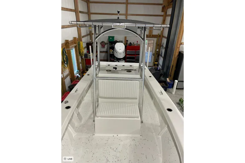 Slide: The Image of 2024 C-Hawk 23 Center Console boat in a garage, showcasing seating and console. - 3